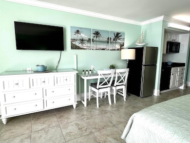 Tiled bedroom with freestanding refrigerator and ornamental molding