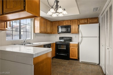Kitchen with visible vents, black appliances, a ch