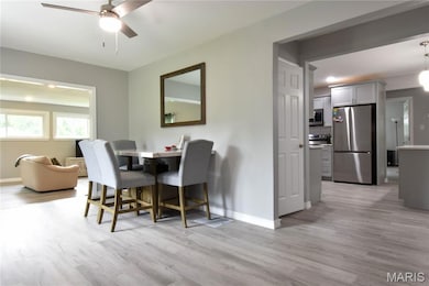 Dining room with light wood finished floors and a ceiling fan