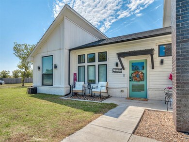 Doorway to property featuring a yard, roof with shingles, brick siding, and board and batten siding
