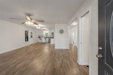 Unfurnished living room with light wood-style floors and ceiling fan