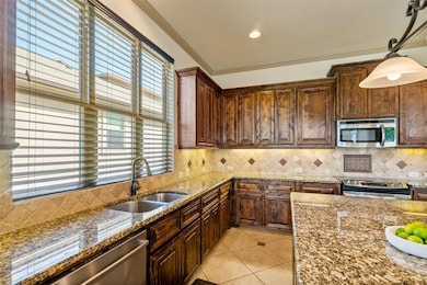 Kitchen with dark stone counters, light tile patt