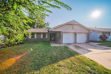 Single story home with a garage and a front lawn