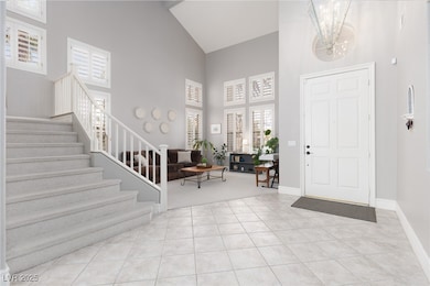 Entryway featuring stairway, a notable chandelier,