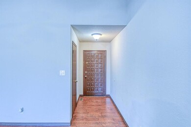 Entryway to front door with baseboards and wood fi
