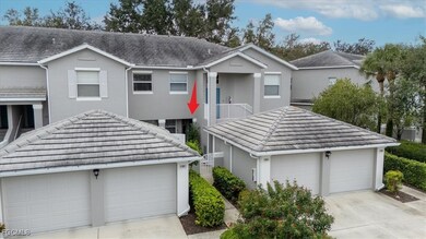 View of front of house with a balcony, stucco siding, a tiled roof, and driveway