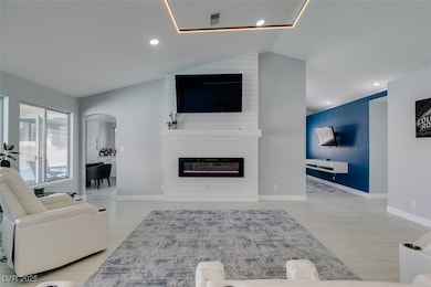 Living area featuring lofted ceiling, arched walkw