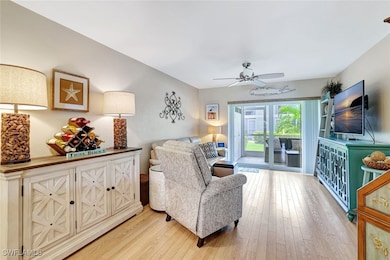 Living room with light wood-style flooring and a ceiling fan