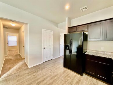Kitchen with black refrigerator with ice dispenser