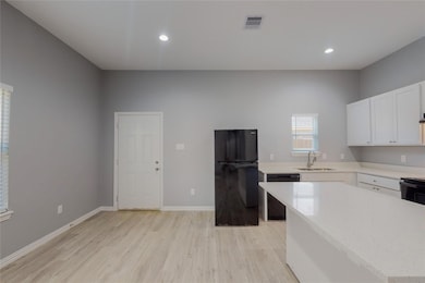 Kitchen featuring black appliances, sink, light wo