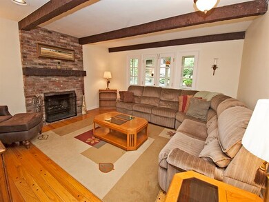 The brick fireplace, warm hardwood floors & beamed