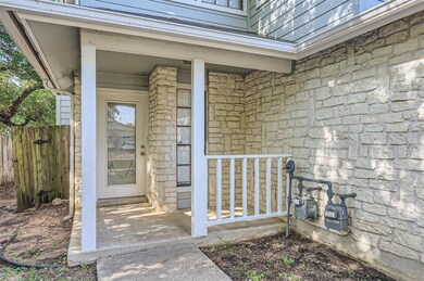 Property entrance featuring stone siding and fence