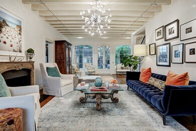 Gorgeous living room with beamed ceiling, fireplace, wall of windows and French Doors to the stunning terrace and pool
