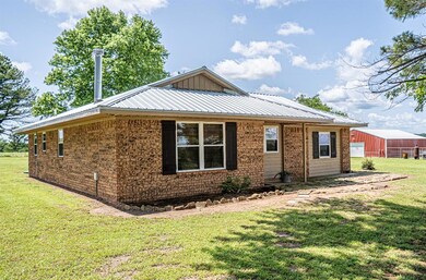 View of front of house with a front yard, brick siding, and metal roof