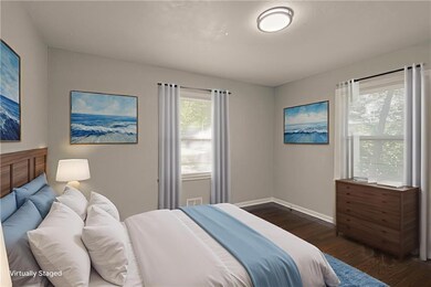 Bedroom with dark wood-style floors and baseboards