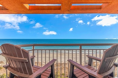 Balcony featuring a water view and a beach view