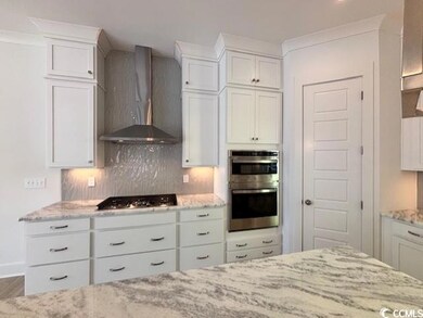 Kitchen with white cabinets, light stone counterto