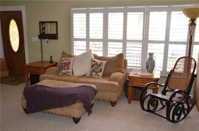 Large carpeted living room upon entry