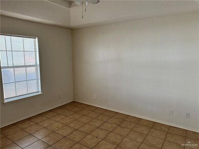 Spare room featuring healthy amount of natural light, a ceiling fan, and light tile patterned floors