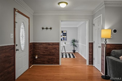 Foyer featuring crown molding and hardwood / wood-style floors