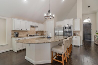 Kitchen featuring a center island with sink, stainless steel appliances, white cabinets, and sink