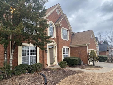 View of front of home with brick siding, roof with shingles, and driveway