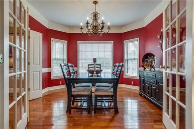 Separate Dining Room with bay windows, hardwoods, French doors, pronounced chair rail, and moldings.