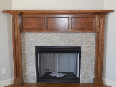 Detailed view of a tile fireplace and baseboards