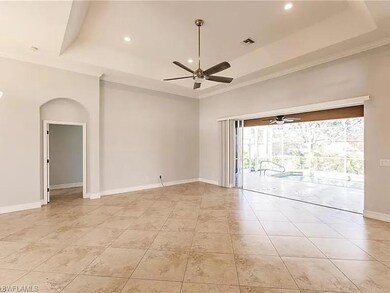 Empty room with a tray ceiling, a towering ceiling
