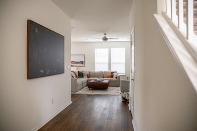 Hallway featuring dark wood-type flooring and bas
