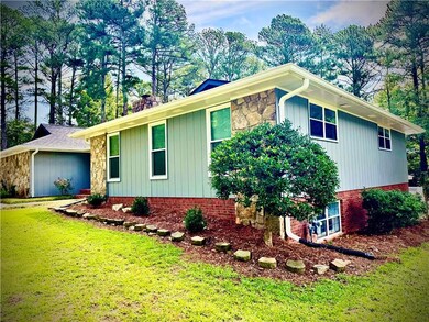 View of side of home with a yard and stone siding