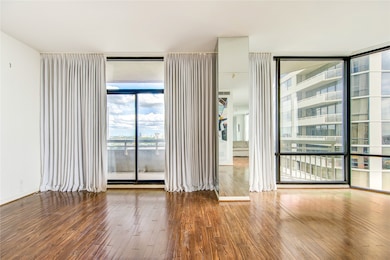Wall-to-wall windows frame sweeping city views in this bright, open-concept living space.