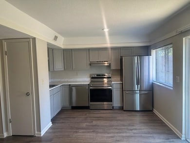 Kitchen featuring gray cabinets, appliances with stainless steel finishes, and light countertops