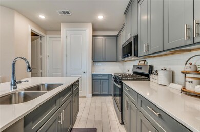 Kitchen featuring visible vents, a sink, decorativ