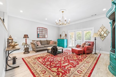 Living room with crown molding, a chandelier, and 