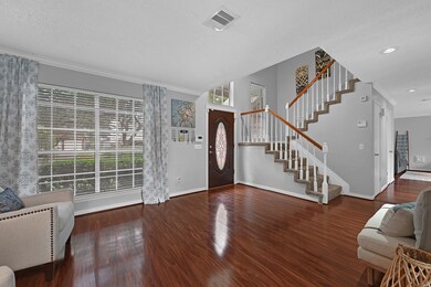 The grand staircase features white balusters and w