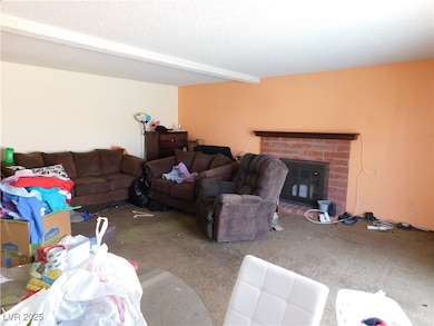 Living area featuring a textured ceiling, carpet f