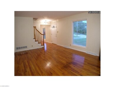 Spacious living room with hardwood floors and plen