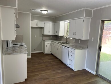 Kitchen with dark hardwood / wood-style flooring, white appliances, backsplash, and white cabinetry