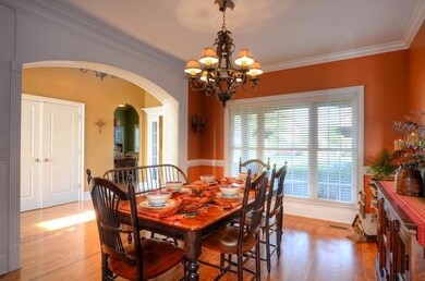 What a beautiful open formal dining room with butlers pantry  overlooking the front garden.