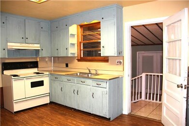 Kitchen has original cabinets and plumbing just reworked to allow flexibility where washer/dryer connections are.  Could be reworked for nice open concept floor plan.  All rooms original wood and tile except for kitchen, smallest bedroom, and baths. 