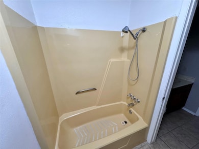 Bathroom with tile floors and bathing tub / shower