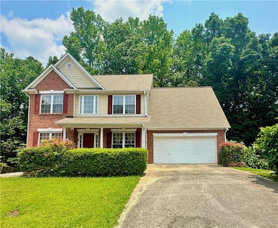 View of front of house with a garage, concrete driveway, a front lawn, and brick siding