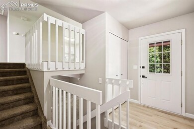 Foyer entrance with light wood finished floors, stairway, and baseboards