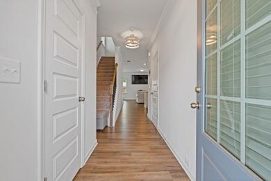Corridor with light wood finished floors and ornamental molding