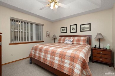 Carpeted bedroom featuring ceiling fan and a textured ceiling