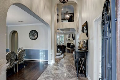 Step inside the foyer to be greeted by soaring two-story ceilings with stunning chandeliers, and dazzling tile floors. An executive study (not pictured) is immediately to your right behind French doors.