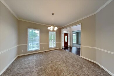 Foyer featuring dark carpet, a chandelier, ornamen
