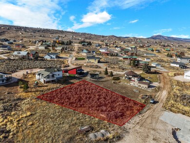 Aerial perspective of suburban area with property parcel outlined and mountains