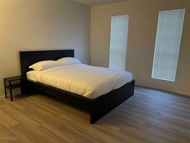 Bedroom with wood finished floors and baseboards